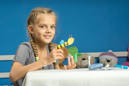 Merry girl plays in a makeshift finger puppet show
