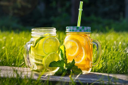 Lemonade in a glass mug-bank on a background of green grass