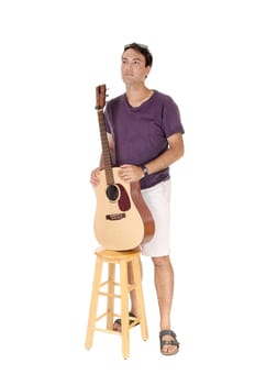A handsome young man standing in a burgundy shirt holding his guitar,.looking away, isolated for white background.