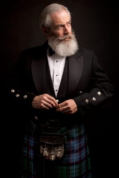 close up of senior man with grey hair and full beard, wearing scotting kilt on dark background