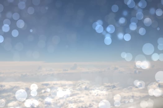 Beautiful abstract bright blue cloudy sky texture with bokeh circles. Space for text.