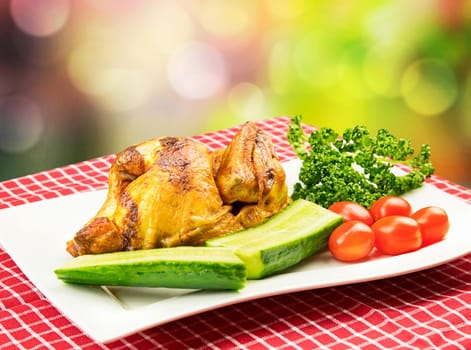Roasted half chicken with tomatoes, cucumber and parsley on a white plate in BBQ picnic style against bright multicolor background. Concept advertisement.