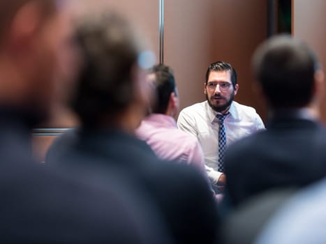 Skiled businessman presenting project to his work team at informal company business training meeting. Business people in the conference room. Business and Entrepreneurship concept.