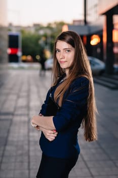 Successful businessman, standing against the backdrop of buildings holding folder with sales charts. City business woman working.