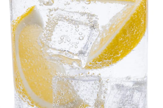 Slices of fresh juicy yellow lemon with ice in water.