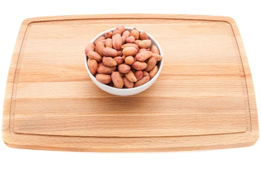 Mixed nuts in a metal brown bowl on a white wooden cutting board.