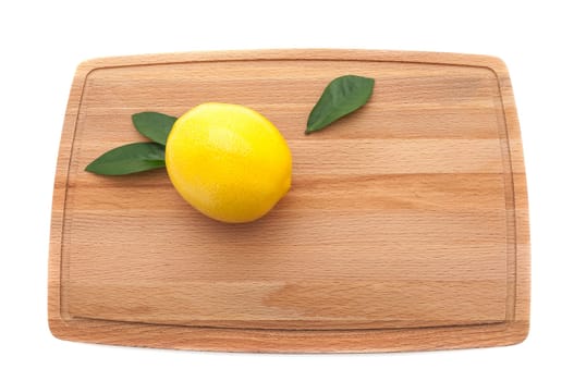 A pair of limes and a lemon wait to be cut on a butcher block cutting board