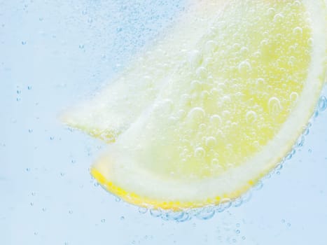 slices of fresh juicy yellow lemon in soda.