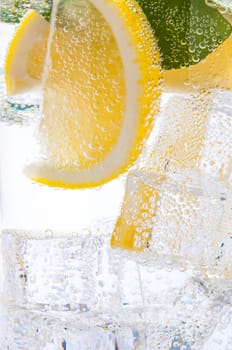 Refreshing, tasty, sweet lemonade with lemon wedges and ice cubes.