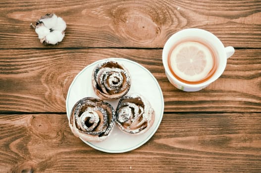 Biscuits with powdered sugar and tea with lemon.