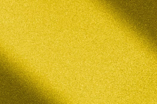 Granite background of golden color with small dots. Darkening left and right diagonally. Blurred.