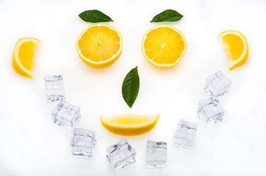 Bright lemon slices, green leaves and ice cubes in the shape of a face. healthy lifestyle.
