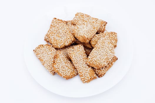 Homemade cookies with sesame on a white plate.
