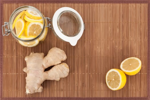 Ginger and lemon in a jar on a bamboo mat