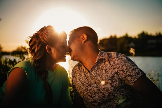 Romantic couple standing and kissing on background summer lake sunset