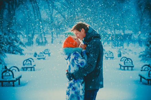 beautiful young couple kiss on snow park background