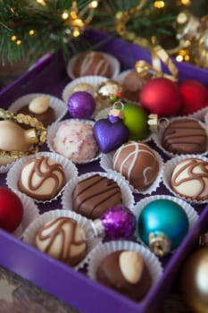 Box of chocolates with colorful baubles for a Merry Christmas