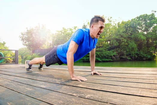 Attractive asian man doing push up exercise at outdoor