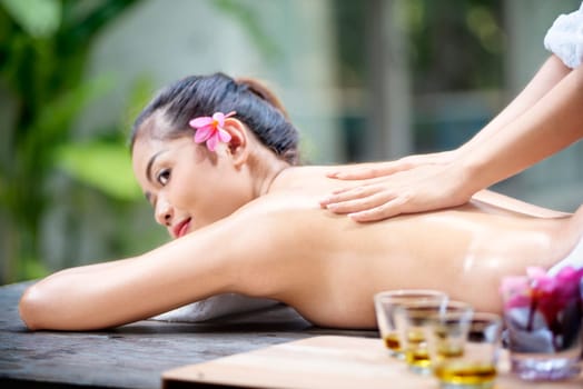 Smiling asian woman relax and enjoying massage in spa salon