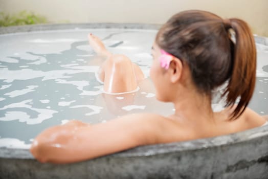 Rear view of asian woman relaxing on the bathtub