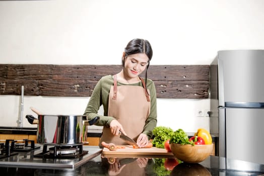 Pretty asian woman is preparing food in the kitchen