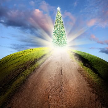 conceptual image of road and decorated shiny Christmas tree over cloudy sky with beam of light
