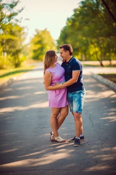 Romantic young couple kissing on background summer forest
