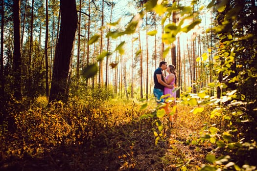 Romantic young couple kissing on background summer forest