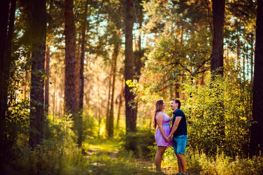 Romantic young couple kissing on background summer forest