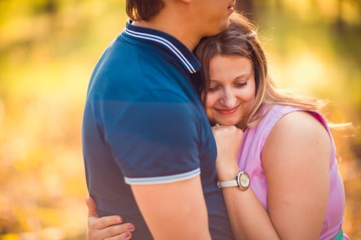 Romantic young couple kissing on background summer forest