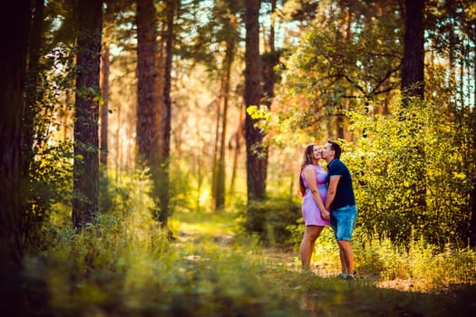 Romantic young couple kissing on background summer forest