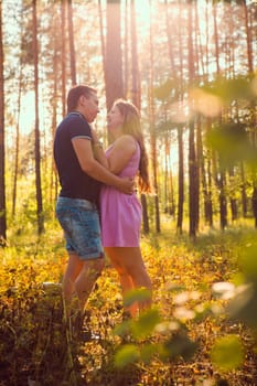 Romantic young couple kissing on background summer forest
