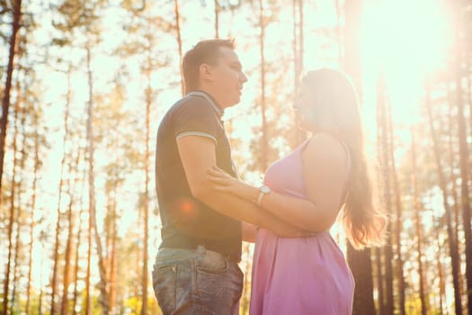 Romantic young couple kissing on background summer forest