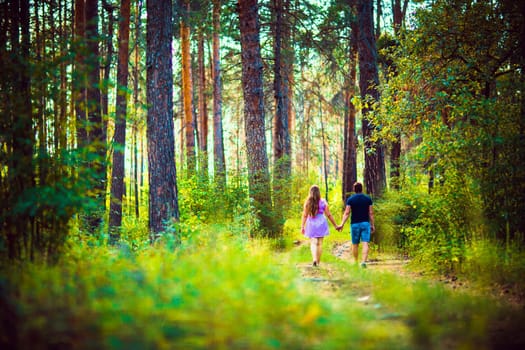 Romantic young couple kissing on background summer forest