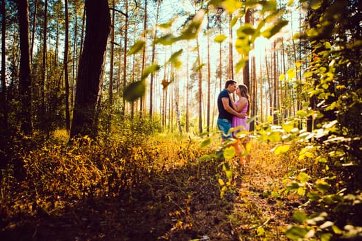 Romantic young couple kissing on background summer forest