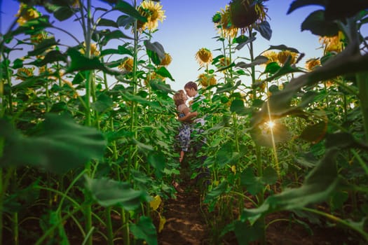 Romantic couple standing and kissing on background summer meadow sunflower sunset