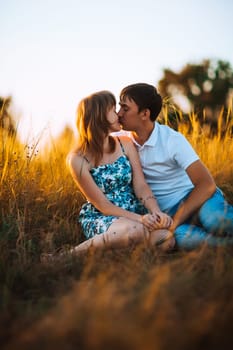 Romantic couple standing and kissing on background summer meadow sunset