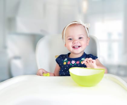Child sitting at table empty space.Kid's nutrition advertisement design.Baby eating.