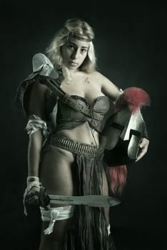 Ancient woman warrior or Gladiator posing in a dark background