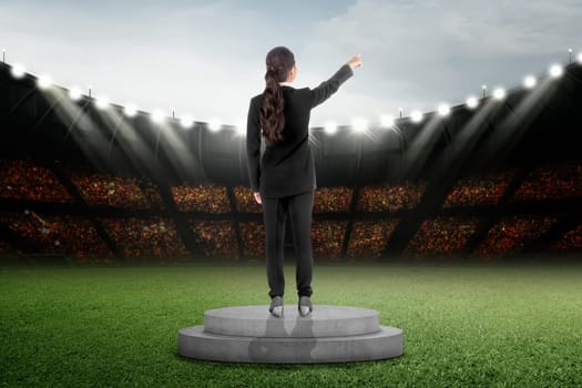 Rear view of asian business woman standing on podium at stadium