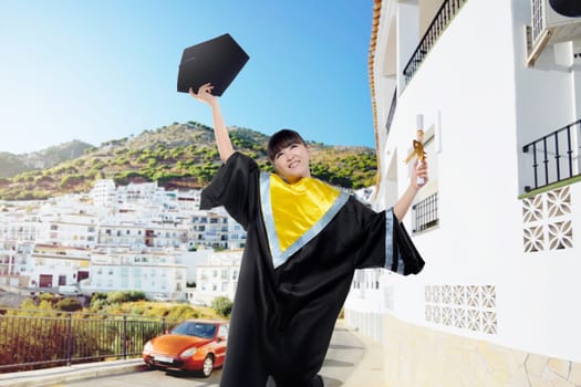 Attractive asian woman throwing her graduation cap after graduation ceremony