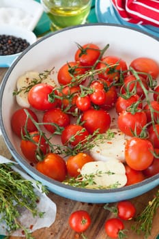 Roasting vine tomatoes with garlic and thyme in a pan