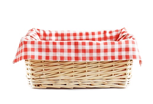 Empty straw basket with checkered red linen napkin isolated.