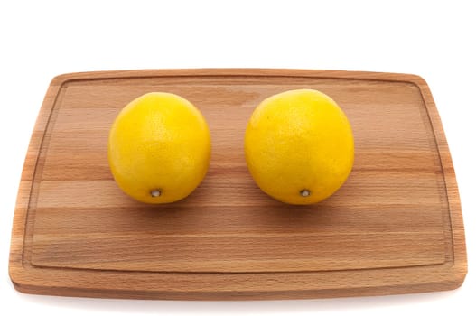 two yellow bright juicy lemon on a cutting board