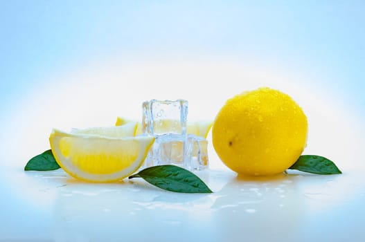 a whole fresh yellow lemon, slices of lemon, green leaves, cubes of ice, and on a blue background. isolated.