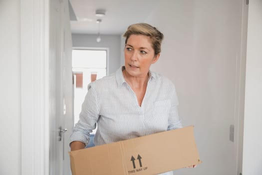 Mature woman is moving boxes in to her new home.