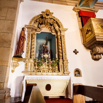 View of side chapel with a beautifully carved woodwork altarpiece including Solomonic columns of the baroque Church of St Peter in the historic town of Trancoso, Portugal.