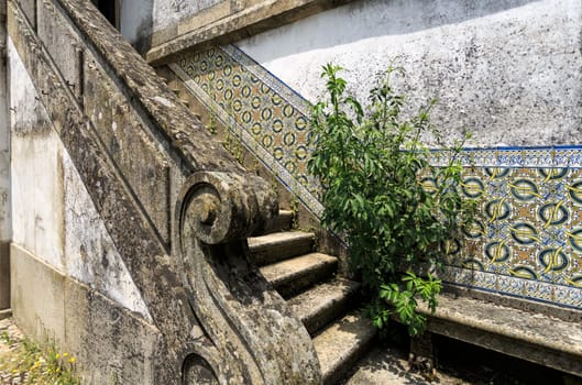 Detail of a beautiful granite stone staircase with decorating tiles on the side wall of an old house in the historical centre of Trancoso, Portugal