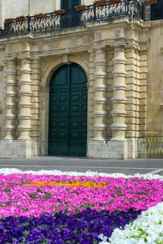Building and flowers in street in downtown of Valleta, Malta