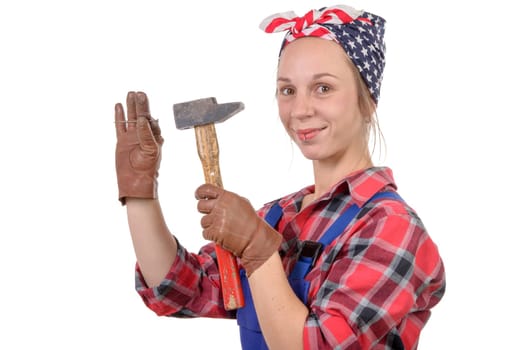 young woman handyman drive a nail with a hammer